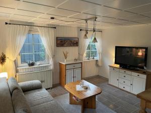 a living room with a couch and a flat screen tv at Ferienhaus Fischerhaus in Zinnowitz