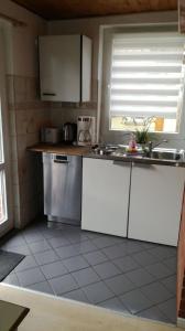 a kitchen with white cabinets and a sink and a window at Ferienhaus Ralf in Zinnowitz +6 photos