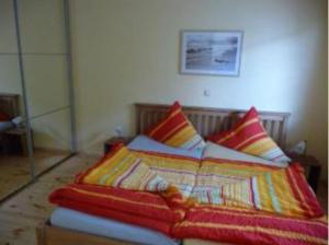 a bed with colorful blankets and pillows in a room at Ferienhaus Fredy in Zinnowitz