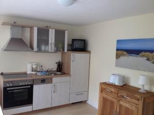 a kitchen with a stove and a sink and a refrigerator at Ferienwohnung Johannes in Zinnowitz