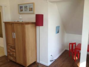 a room with a red floor lamp and a dresser at Ferienwohnung Klabautermann in Zinnowitz