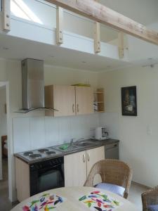 a kitchen with a stove and a table with chairs at Ferienhaus Molly in Zinnowitz
