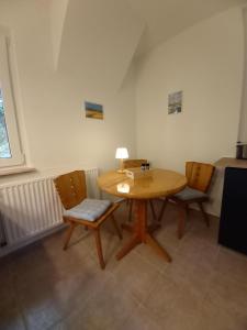 a wooden table with chairs and a lamp on it at Ferienhaus Lukas in Zinnowitz