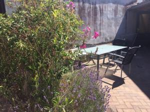 a table and chairs in a garden with flowers at Ferienwohnung Ida in Ahlbeck +7 photos