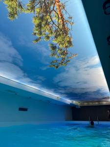 a ceiling with a painting of a tree in a swimming pool at Hotel Sunčana planina - Wellness & Spa - Kopaonik - Sunny Mountain Apartments in Kopaonik