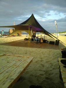 a tent on the beach with a person sitting in it at Bungalow Iris in Zinnowitz +6 photos