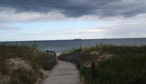 a path to the beach with a boat in the water at Bungalow Iris in Zinnowitz