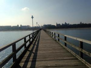 a wooden boardwalk stretches out over the water at Bungalow Iris in Zinnowitz