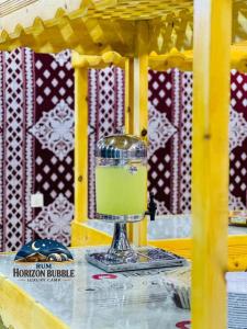 a green drink in a snow globe on a table at RUM HORIZON BUBBlE LUXURY CAMP in Wadi Rum +63 photos