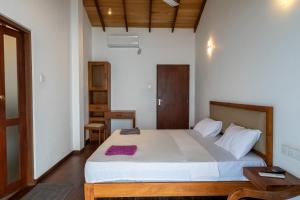 a bedroom with a large bed in a room at Surfside Serenity - SS Beach in Ahangama