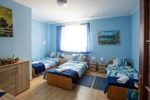a bedroom with three beds and a window at noclegi u zabki in Ełk