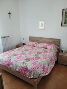 a bedroom with a bed with a floral comforter at AMPIO BILOCALE Caorle LUNGOMARE LEVANTE in Caorle