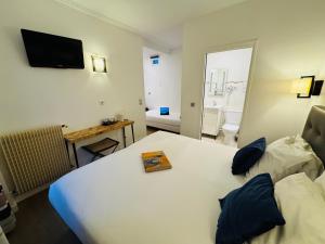 a hotel room with a bed with a book on it at Hôtel L'Amiral in Paris