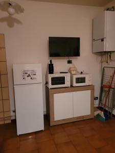 a kitchen with two microwaves and a tv on the wall at AMPIO BILOCALE Caorle LUNGOMARE LEVANTE in Caorle