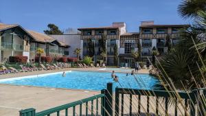 a pool at a hotel with people playing in it at Cosy MO-MAÂ Golf, Océan et Plages in Moliets-et-Maa