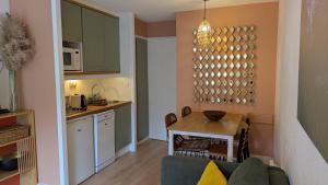 a kitchen and living room with a couch and a table at Cosy MO-MAÂ Golf, Océan et Plages in Moliets-et-Maa