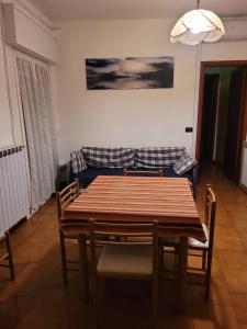a dining room with a table and a couch at AMPIO BILOCALE Caorle LUNGOMARE LEVANTE in Caorle
