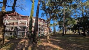 an apartment building with trees in the foreground at Cosy MO-MAÂ Golf, Océan et Plages in Moliets-et-Maa