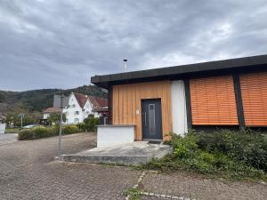 a building with a black door on a street at Zweizimmer-Häuschen im Schwarzwald in Schopfheim