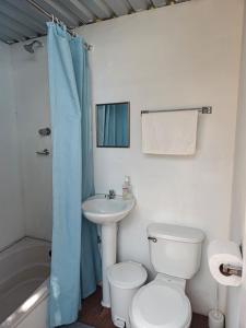 a bathroom with a toilet and a sink and a shower at Las Terrazas de el Alto in Chalatenango