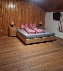 a bedroom with a bed with red and white pillows at Uhlerhof in Stumm