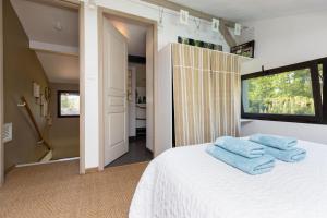 a bedroom with a white bed with blue towels on it at Maison humanesens in Léon +21 photos