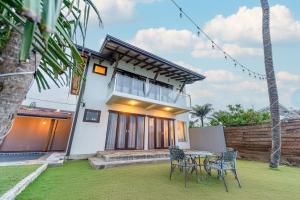 a house with a table and chairs in the yard at Surfside Serenity - SS Beach in Ahangama