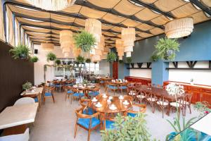 a restaurant with tables and chairs and potted plants at Hotel Guiant in Santa María del Río