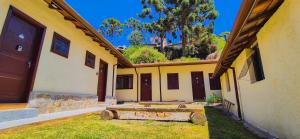 a building with a bunch of wooden benches in the yard at A Nossa Casinha Capivari - 400m do Parque Capivari in Campos do Jordão