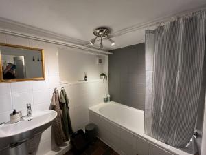 a bathroom with a tub and a sink and a shower at Heltoften Bed & Breakfast in Nykøbing Mors +35 photos