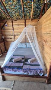 a bed in a room with a net at Terema Lodge in Kanuma