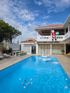 a swimming pool in front of a house at The White Palm Villa & Pool in Khon Kaen