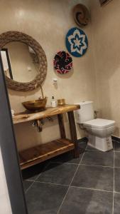 a bathroom with a toilet and a sink and a mirror at La Perle Ourika Valley Guest House in Ourika