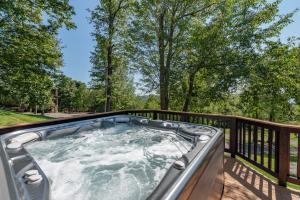 a hot tub on a deck with trees at Tips Up by Railey Vacations in McHenry