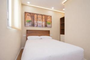 a bedroom with a white bed and a painting on the wall at San Ambrosio in Granada
