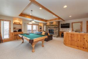 a living room with a pool table and a fireplace at Tips Up by Railey Vacations in McHenry
