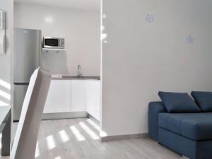 a living room with a blue couch and a sink at Apartamentos los Acantilados Nº 1 Cobreces in Cóbreces