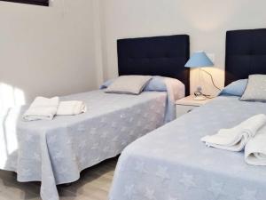 two beds sitting next to each other in a bedroom at Apartamentos los Acantilados Nº 1 Cobreces in Cóbreces