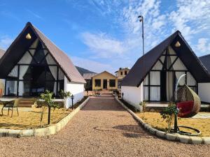 a house with two peaked roofs with a gravel driveway at THE RiYASAT SARISKA in Ajabgarh