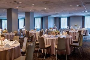 a banquet room with tables and chairs with white linens at Courtyard Grand Rapids Downtown in Grand Rapids +29 photos