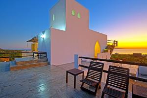 a house with two chairs and a sunset in the background at The Moroccan Palace Entire Villa in El Sargento