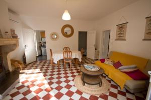 a living room with a couch and a table at Gîte Aux Tuileries in Noaillan