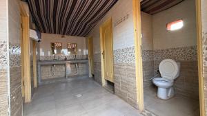 a bathroom with a toilet in a room at Wadi Rum Trip Bedouin Camp in Wadi Rum