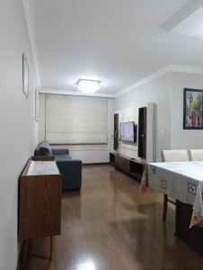 a living room with a couch and a tv at Jonas e Selma Apartmento 3 quartos in Araucária