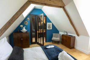 a bedroom with blue walls and a bed and a chair at La Résidence Périgourdine Meublé Tourisme 5 étoiles Luxe in Anlhiac +70 photos