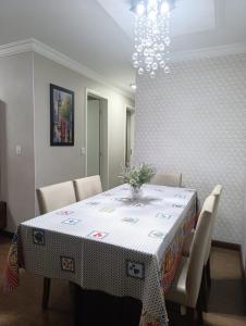 a dining room with a table with chairs and a chandelier at Jonas e Selma Apartmento 3 quartos in Araucária +10 photos