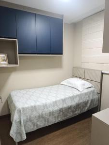 a bedroom with a bed with blue cabinets at Jonas e Selma Apartmento 3 quartos in Araucária