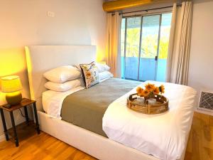 a bedroom with a bed with a tray with flowers on it at Echo Lake view condo - newly renovated - centrally located in Los Angeles