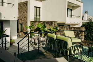 a balcony with two chairs and a plant at Coração da Quinta in Algarvia