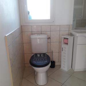 a bathroom with a toilet with a sign on it at L etoile bleue in Fossé